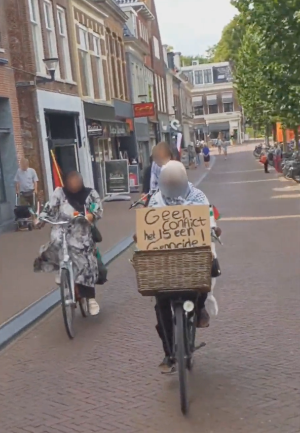 Verschillende personen fietsen met Palestijnse vlaggen op een halfbewolkte dag.
