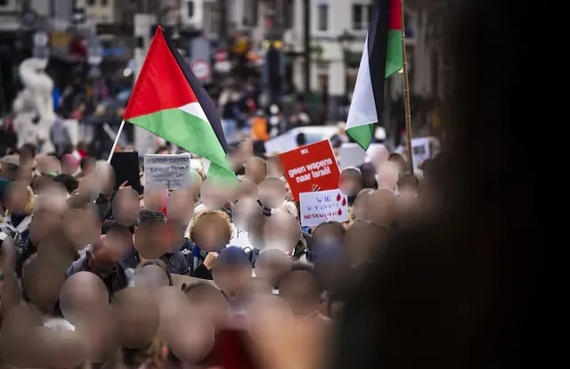 Een menigte met borden en een Palestijnse vlag