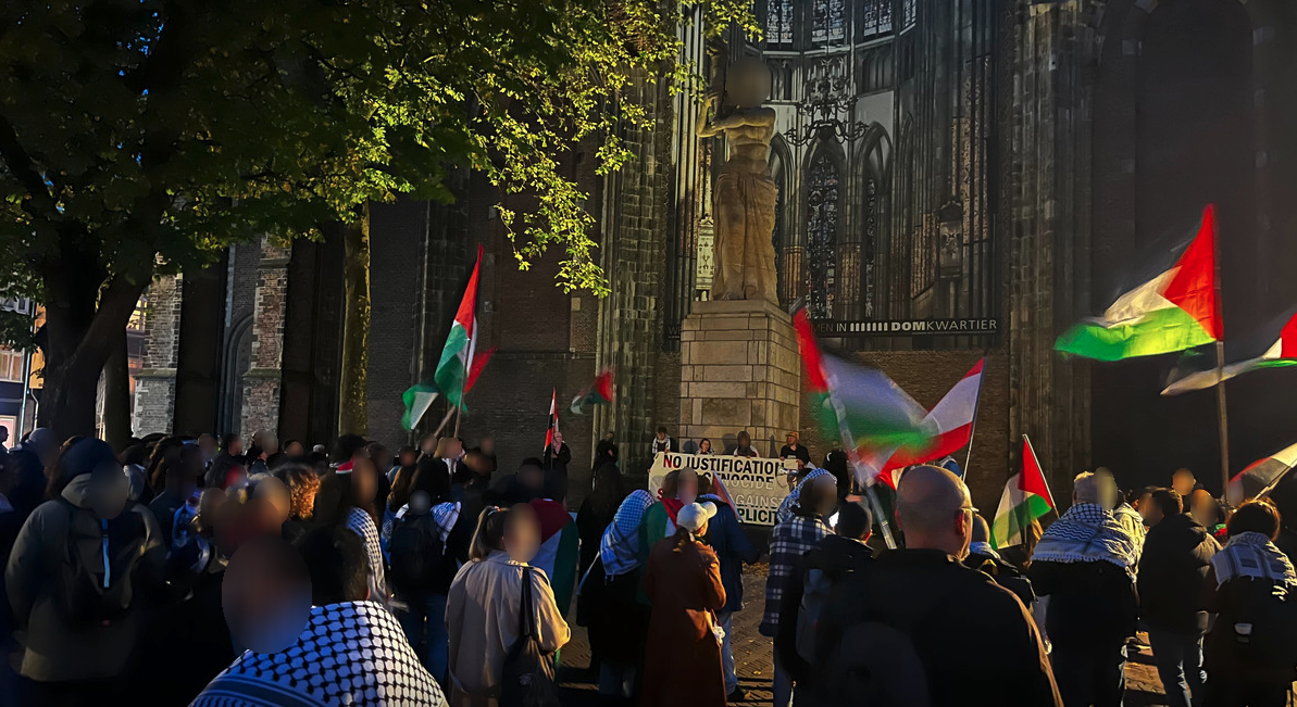 Een groep demonstranten voor de Dom in Utrecht. Ze hebben Palestijnse vlaggen bij zich.